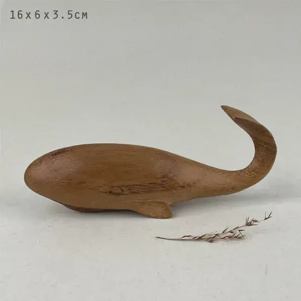Dark wooden whale figurine on a light gray background